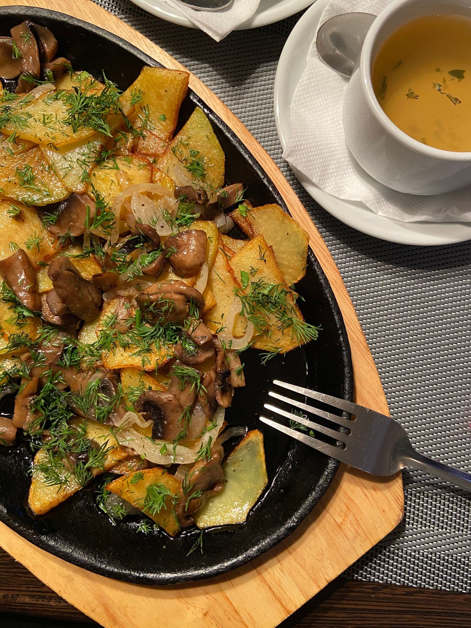 Fried potatoes with mushrooms and dill in a pan